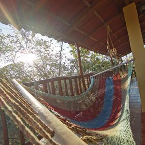 a hammock on a porch with the sun in the background at HOTEL GEORGI CR in Guanacaste