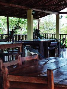 uma mesa de madeira e cadeiras num quarto com árvores em HOTEL GEORGI CR em Guanacaste