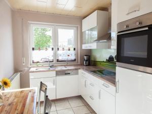 eine Küche mit weißen Schränken und einer Spüle und einem Fenster in der Unterkunft Apartment in Halenfeld near Ski Slope in Sellerich