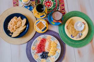 uma mesa coberta com pratos de alimentos e bebidas ao pequeno-almoço em Meraki Boutique Hostel em San Gil