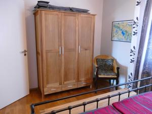 a bedroom with a wooden cabinet and a chair at Ferienwohnung "Müritzuferblick" Objekt ID 12112-5 in Waren