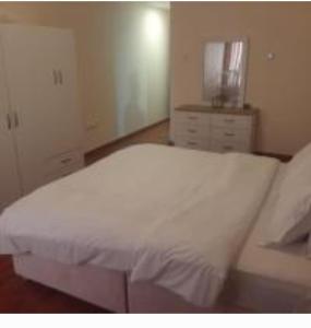 ein Schlafzimmer mit einem weißen Bett und einer Kommode in der Unterkunft Lemas 901 in Ajman 