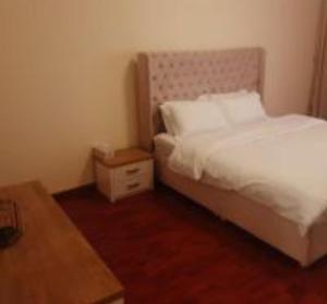 ein kleines Schlafzimmer mit einem Bett und einem Tisch in der Unterkunft Lemas 901 in Ajman 