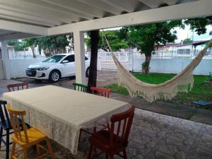 a table and chairs with hammocks in a patio at Casa da Cal in Torres
