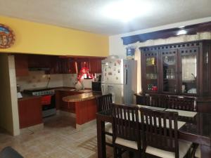 La cuisine est équipée d'un réfrigérateur blanc et de placards en bois. dans l'établissement Casa Mango, à Ciudad Valles