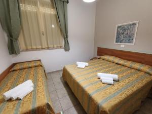 - 2 lits dans une chambre avec des serviettes dans l'établissement Hotel Zeus Lido di Classe Room Only, à Lido di Classe