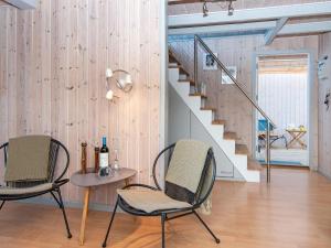 a living room with two chairs and a table and stairs at 6 person holiday home in Hemmet in Falen