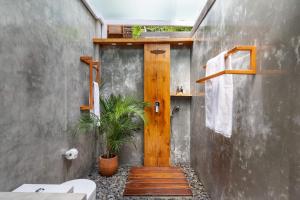 a bathroom with a wooden door and a toilet at Like living in a romantic Balinese painting in Sidemen