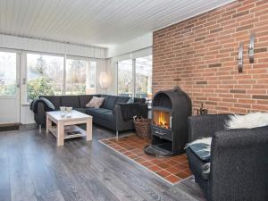 a living room with a brick wall and a fireplace at 6 person holiday home in Hemmet in Falen