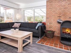 a living room with a couch and a fireplace at 6 person holiday home in Hemmet in Falen