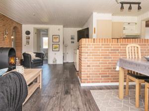 a living room with a brick wall and a table at 6 person holiday home in Hemmet in Falen