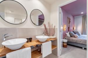 a bathroom with two sinks and two mirrors on the wall at Apartment Turtle at Windsock Beach in Kralendijk