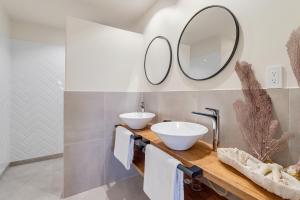 a bathroom with two sinks and a mirror at Apartment Turtle at Windsock Beach in Kralendijk