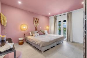 ein Schlafzimmer mit einem Bett und einer rosa Wand in der Unterkunft Apartment Turtle at Windsock Beach in Kralendijk