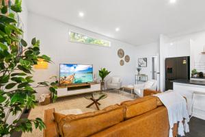 ein Wohnzimmer mit einem Sofa und einem Flachbild-TV in der Unterkunft Getaway On Little in Daylesford