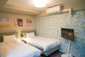a hotel room with two beds and a tv at Sapporo Stay Nakajima Park in Sapporo