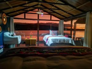 a bedroom with a bed and a large window at Amalia Titicaca Lodge in Puno
