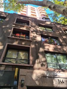 um edifício alto com janelas e uma árvore em Centro de Mendoza departamento em Mendoza
