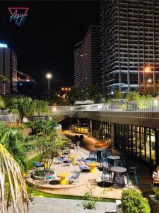 クイニョンにあるFLC SEA TOWER - 4 SEASONS Apartmentの夜の街にある椅子とテーブルのあるパティオ