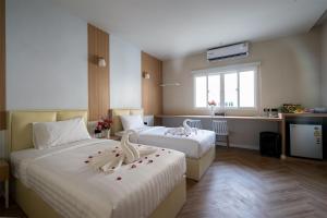een hotelkamer met 2 bedden en een keuken bij Grandbangsaray in Na Jomtien