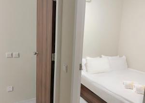 a bedroom with a bed with white sheets and pillows at Hotel Calmo Chinatown in Singapore