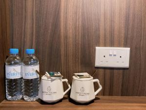 two bottles of water are sitting on a shelf at Hotel Calmo Chinatown in Singapore