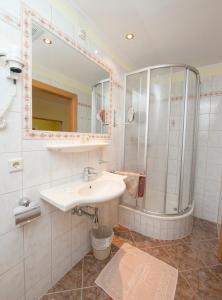 a bathroom with a sink and a shower at Hotel Lebzelter in Zell am See