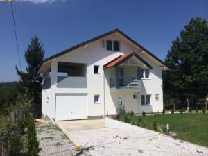 a white house with a garage at Holiday Home SL in Sarajevo