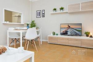 uma sala de estar com uma televisão e uma mesa em Cosy 3-bedroom apartment for 6-8 people just 50m from the beach em Salou