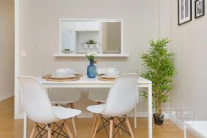 uma mesa de jantar branca com cadeiras brancas e um espelho em Cosy 3-bedroom apartment for 6-8 people just 50m from the beach em Salou
