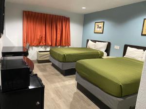 um quarto de hotel com duas camas e uma televisão em Executive Inn em Hobbs