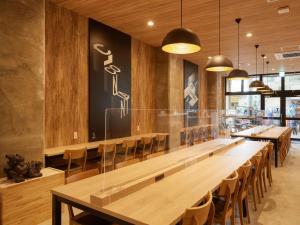 a dining room with a long table and chairs at CABIN&HOTEL CONSTANT NAHA in Naha