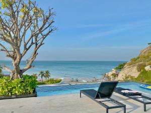 a chair sitting next to a swimming pool next to the ocean at Seaview 2 BR Beach front Vacation HuaHin in Hua Hin