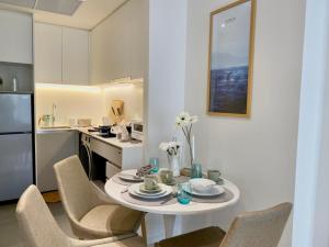 a kitchen with a table and chairs and a kitchen with a refrigerator at Seaview 2 BR Beach front Vacation HuaHin in Hua Hin