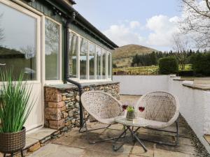 two chairs and a table on a patio at Glen Cottage in Penrith