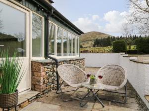 two chairs and a table on a patio at Glen Cottage in Penrith