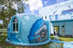 a blue house with a whale painted on it in front of a building at Atlantis Dome Villa Lot 3108 in Kampong Alor Gajah