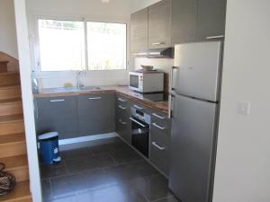 a kitchen with a refrigerator and a sink at Villa Régina in Trouville-sur-Mer