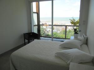 two beds in a bedroom with a large window at Villa Régina in Trouville-sur-Mer