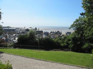 een uitzicht op het strand vanuit een park bij Villa Régina in Trouville-sur-Mer