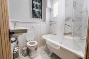 ein weißes Badezimmer mit einem WC, einer Badewanne und einem Waschbecken in der Unterkunft GABLE COTTAGE - One Bed Cottage Close to Holmfirth and the Peak District in Hepworth + 20 Fotos