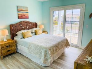 a bedroom with a bed and a large window at 1030 Ocean home in Holden Beach