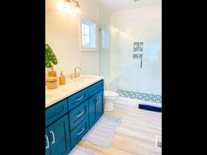 a blue bathroom with a sink and a shower at 1030 Ocean home in Holden Beach