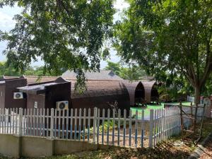 a white picket fence in front of a house at 8 Wooden Inn LOT 1806 in Kampong Alor Gajah