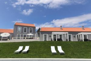 two lounge chairs on a lawn in front of a house at Casa do Melgaco, Turismo Rural in Casal do Pardo