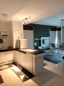a kitchen and living room with a counter and a microwave at Homestay Apartment KB @ D'perdana Condo in Kota Bharu +6 photos