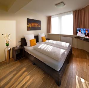 a bedroom with a large bed with a television in it at GuestHouse Mannheim in Mannheim