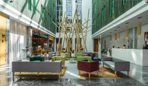 a lobby with chairs and tables in a building at Al Khoory Courtyard Hotel in Dubai