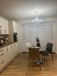 cocina y comedor con mesa y sillas en Cosy double room with private bathroom homestay en Caldecote