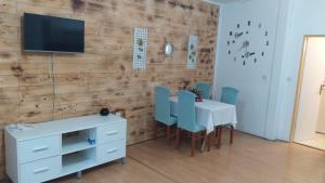 a dining room with a white table and blue chairs at Apartments Ante in Tribunj